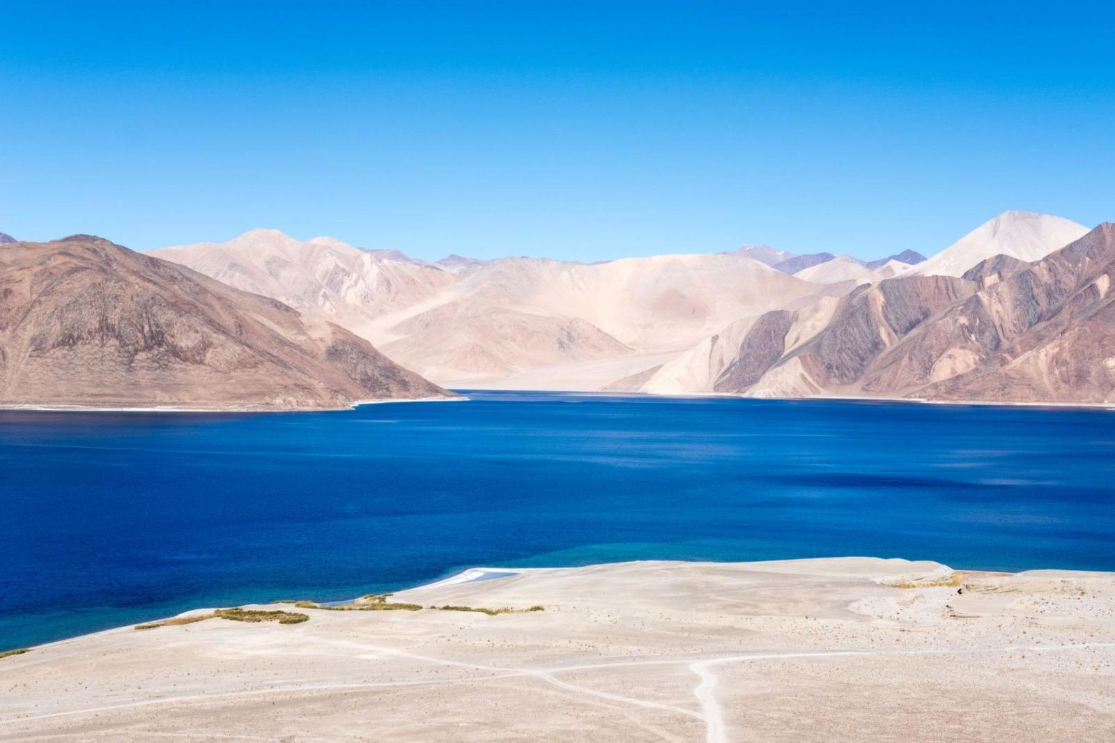 Deep blue Pangong Lake with bare mountains behind